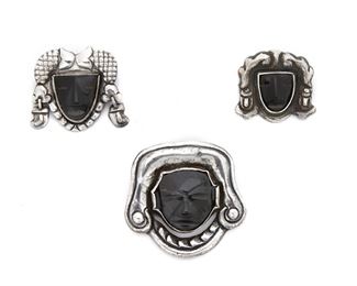 85
A Group Of Matl Silver And Onyx Mask Brooches
Circa 1935-1948; Mexico City, Mexico
Variously stamped: Matl [in script] / Matl [in box] / 0.900
Comprising a brooch centering a carved onyx mask (2" L x 2.25" W), a brooch centering a carved onyx mask suspending ear pendants (1.5" L x 1.5" W), and a brooch centering a carved onyx mask (1.25" L x 1.5" W), 3 pieces
60 grams gross
Estimate: $500 - $700