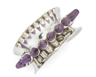 122
An Antonio Pineda Sterling Silver And Amethyst Cuff Bracelet
Circa 1953-1979; Taxco, Mexico
Crown mark for Antion Pineda; Further stamped: Eagle 17 / Hecho en Mexico / Silver / 970 / ZZ733
The rigid concave design centering a line of 'spiked' amethyst cones
6.25" C x 1.425" H, wrist opening: 1"
86 grams
Estimate: $1,000 - $2,000