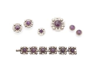 198
A Group Of Fred Davis Silver And Amethyst Jewelry
Pre-1948 and Post-1948; Mexico City, Mexico
Variously stamped: FD [Fred Davis] / Made in Mexico / Silver / Mexico / Eagle 22; One earring set attributed to Davis with hallmark covered by screw backing; One earring set attributed to Davis with no hallmarks
Comprising a stylized medallion amethyst set link bracelet (7" L x 1" W) together with two matching brooches (2" L x 1.75" W and 1" L x 1" W), a pair of matching screw-back earrings (1.25" Dia.), and a pair of round cabochon amethyst screw-back earrings (.75" Dia.), 7 pieces
101.5 grams
Estimate: $700 - $900