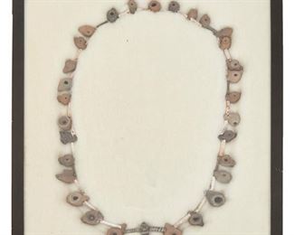 211
A Pre-Columbian Pottery Shard Necklace
Pre-historic or later
With diminutive vessel-shaped beads and a central carved stone fish pendant
31" L; Case: 16.125" H x 12.125" W
Estimate: $500 - $700