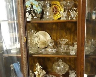 China cabinet with glassware Crystal covered candy dishes plates penguin statue cups and saucers cake plates