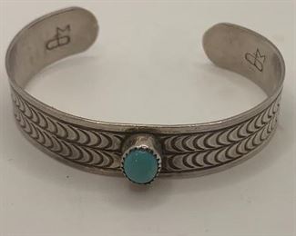 Silver and turquoise cuff  is 1/2" thick and measures 2.5" by 2" and the turquoise measures 3/8" by 1/4". It is hallmarked.