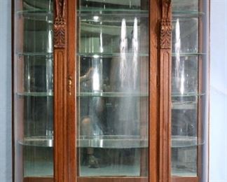 079Aa - Large solid oak curved glass china cabinet with claw feet and carved griffins on serpentine front, attrib. to R.J. Horner, 71 in. T, 55 in. W, 18 in. D.