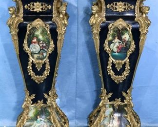 147 - Pair of rococo French pedestals, black and gold with scenes painted on transfer plates, gold bust figures on each corner and gold C scroll feet, 49 in. T, 17 in. Sq.