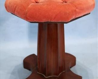 344 - Empire mahogany column base piano stool with pink velvet upholstery, 17 in. T, 14 in. R. This stool is the fluted stool which goes with the Chickering "Cocked Hat" piano.