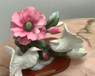 Beautiful ceramic statue of white doves and pink flower. 
