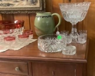 Crystal pieces on buffet along with pottery pieces.