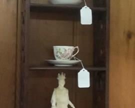 Wall hangings with Alabaster Greek figurines and cup and saucers.