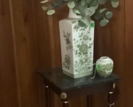 Mahogany stand with green marble top in green vase and greenery.