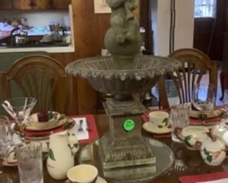 The fountain with boy inside in the middle of the table.
