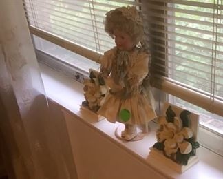 Besutiful doll in window with book ends.