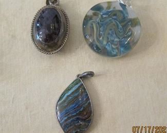 THREE PENDANTS, ONE IN STERLING AND THE LOWER PENDANT HAS PLATINUM CASE.