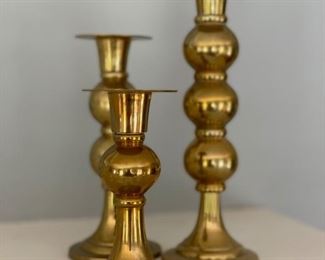 Set of three brass candlesticks.