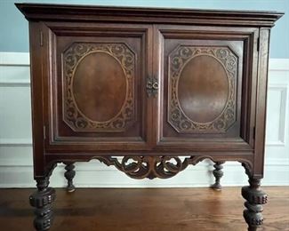 Antique Jacobean-style mahogany cabinet sideboard with turned wood legs and floral cartouche detailing. Circa 1920. Measures 42" W x 32" H x 19" D. Photo 1 of 2.