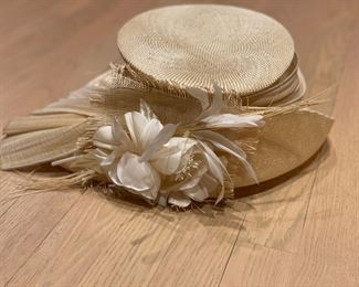 Straw hat with floral and feather adornments. 