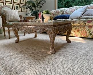 Carved bronzed wood cocktail table with stone top. Measures 45" W x 28" D x 20" H. Photo 1 of 2. 