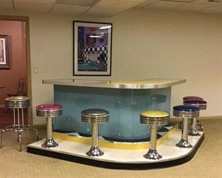 U-shaped 50s-style formica bar with five mounted bar stools and two standing bar stools with vinyl seat cushions. Bar measures 62" x 62" x 24"D.  Stools measure 27" H. 