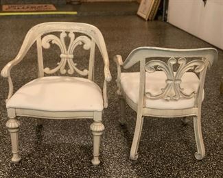 Set of four upholstered metal chairs with fleur de lis detailing on seat back. Each measures 20" D x 24" W x 30" H. 