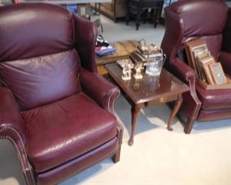 Pair of burgundy leather recliners; end table