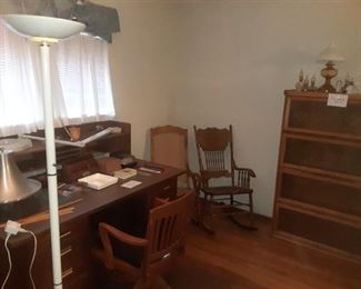 Desk with chair, rocking chairs, glass book shelf and oil lamps