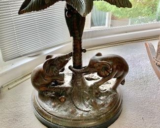 Glass top pedestal table featuring elephants and palm tree.