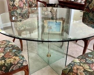 Glass dining table; glass and brass base, beveled glass top; 48” round