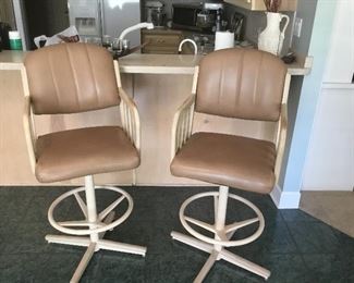 Two tan leather bar stools. 