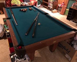 Newcastle pool table with cues and accessories.