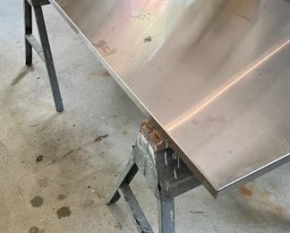 Stainless Steel Table Top Resting on Two Saw Horses 