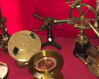 Collection includes antique compasses, galvanometers, spectroscopes, Leyden jars etc. Heliochronometer or sun dial in background left. 