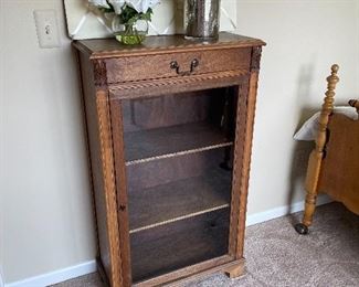 glass front book case/curio cabinet with top drawer, floral arrangements and bullentin board