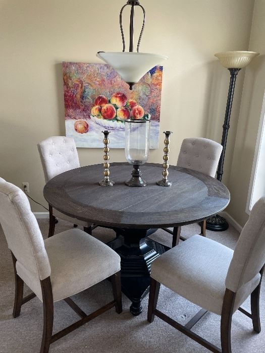 Round kitchen table with 4 side chairs (table has center pedestal), canvas print, floor lamp, and candle holders