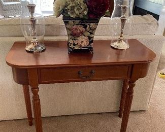 Sofa table with a center drawer, Baldwin brass candle holders, and hand-painted floral tin