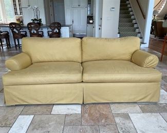 Pale yellow upholstered loose back sofa.  Measures 89" W x 45" D. 