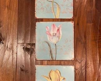 Set of three flower portraits on metal.