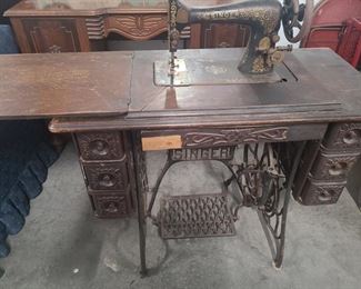 Antique Singer sewing machine with sewing cabinet. Sewing machine pulls up and pushes back down for storage. Cabinet has ornate designs on the wood and has the classic iron treadle with Singer name at it’s center.
Machine is in decent condition for its age.
Measures 37" x 18" x 30". https://ctbids.com/#!/description/share/1009600