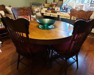 Round oak claw-foot dining table with 6 chairs