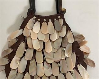 This ladies handbag has beaded shells hanging and moveable. This is a fun handbag you can wear on your wrist.