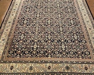 Black border rug. 9 feet by 6 feet 10 inches.