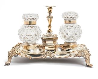 1008
A Silver Plated And Cut Crystal Footed Double Inkwell
Mid-19th Century
With scrolling and floral motifs with central candlestick
7.25" H x 11.375" W x 7" D
Estimate: $300 - $500