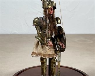 VINTAGE KNIGHT PUPPET | In a glass dome display case, a painted wooden stringed puppet of a knight with long hair dressed in suit of armor with articulating helmet; figure h. 6-3/4 in., dome h. 10-1/2 x dia. 7-3/4 in. 
