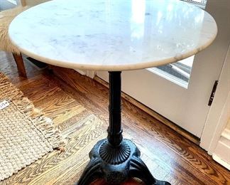 $150.00 iron, pedestal table with claw feet and marble top, 23”diameterx28”high