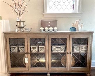 $550.00 washed gray, wooden media center with four glass doors and adjustable shelving, ball feet, 80”x18”x43”
