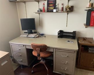Metal desk, filing cabinet, two computer monitors, keyboards, and mice