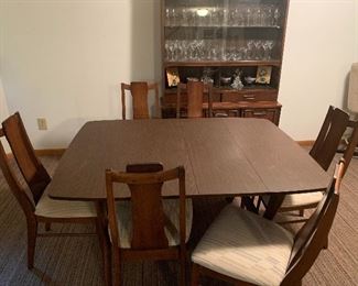 Beautiful mid-century modern table with two leaves and six chairs. Matching mid-century modern glass front China hutch