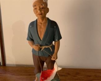 Japanese fisherman statue. Damage on the nose