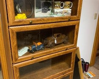 Four door glass front lawyers bookcase, Hand carved wooden car, brass car horn, and unique car inspired coffee mugs