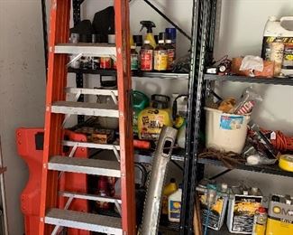 Step ladder, auto creeper, metal shelves, and assorted gardening chemicals
