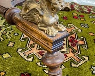 Antique library table with brass gargoyles and claw and ball feet
