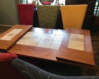 #12	Mid Century table with tile on top and 2 removable drop leaf leaves on the side on   60-96x 32x29 w 8 parson chair in mix colors 	 $275.00 		
